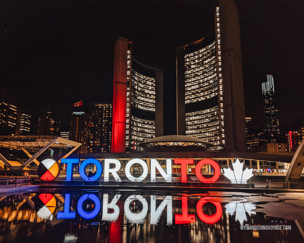 Reflection of the Toronto sign at Nathan Phillips Square at night | With the powerful device in your pocket you can take incredible photos of your travels. Here is the ultimate guide to smartphone travel photography. | My Wandering Voyage travel blog #travel #photography #tips #travelphotography #smartphonephotography